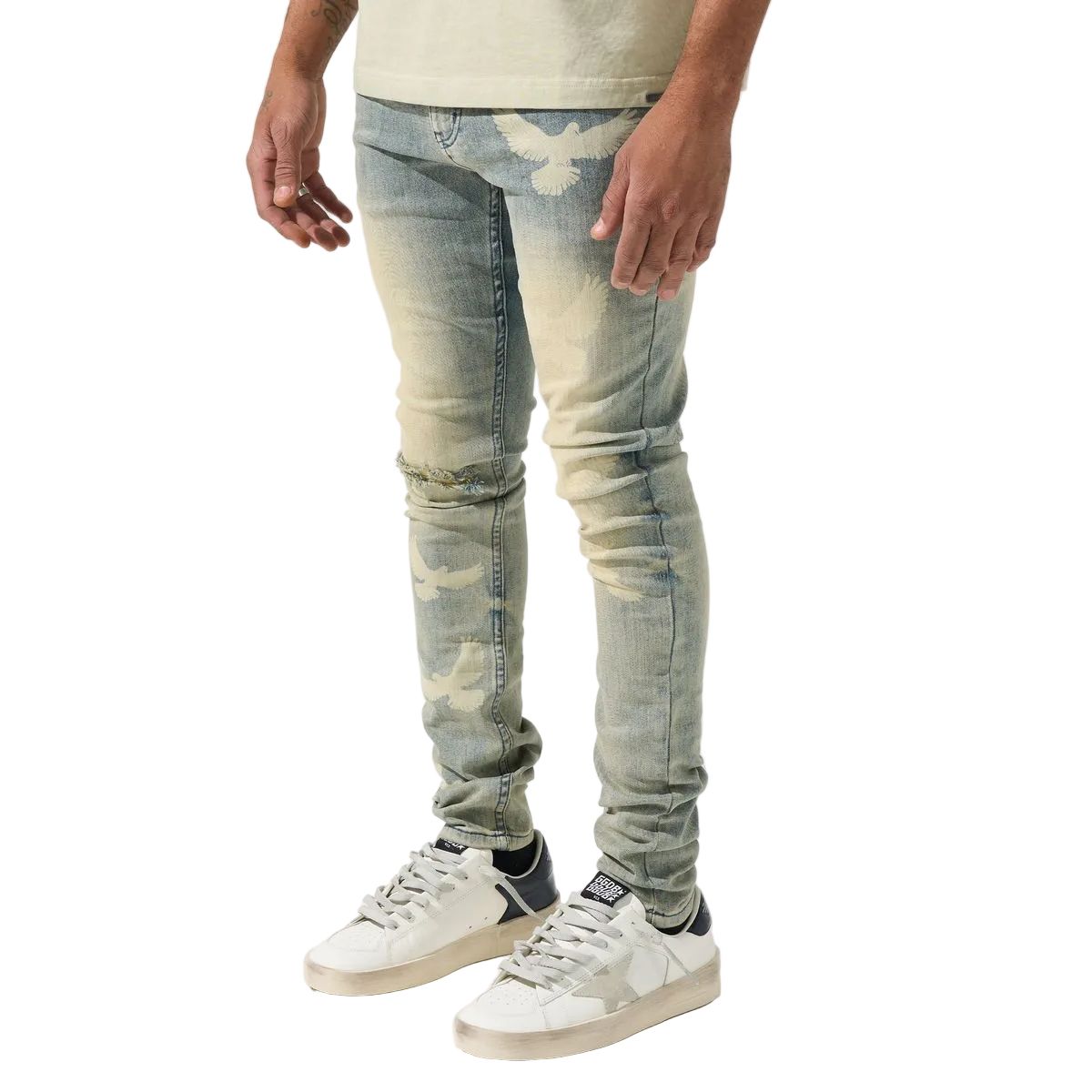 Person wearing light blue distressed jeans and white sneakers on a white background